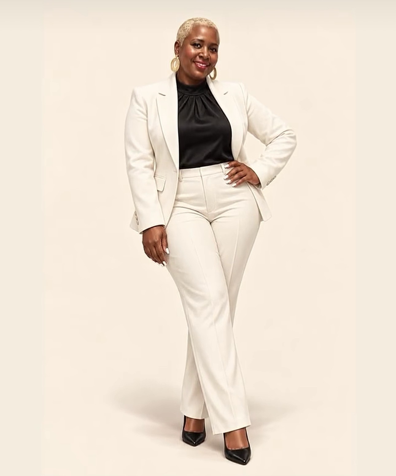 Agnes Kimathi, REALTOR® with ANEW Collective at LPT Realty, standing in an ivory pantsuit against a cream studio backdrop